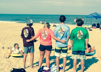 group of four showing the back of their endless summer shirts