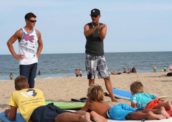 instructors explaining how to surf to kids in Ocean City MD