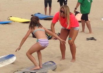 young girl being taught to surf in ocean city md