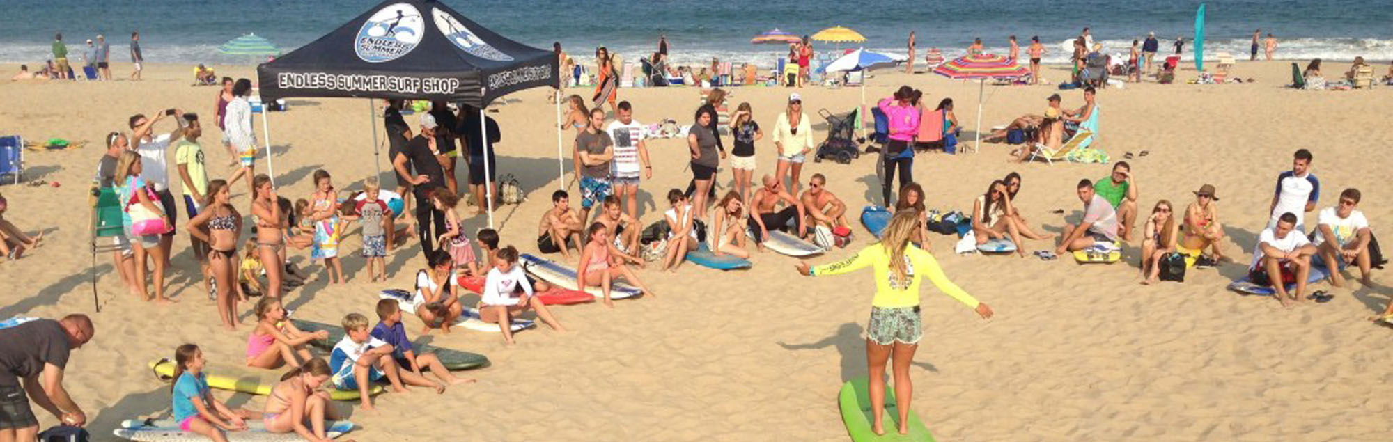 endless summer instructor giving surf lesson to crowd of kids