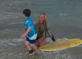 endless summer surf instructor giving young boy surf lesson