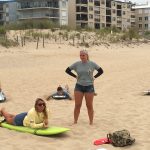 Instructors giving students surf lessons