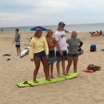 Teenagers standing on surfboard on beach in Ocean City md