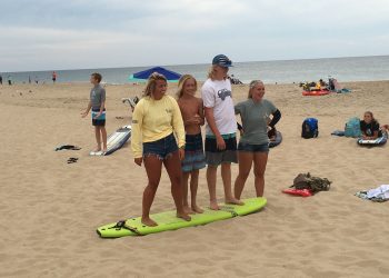 Teenagers standing on surfboard on beach in Ocean City md
