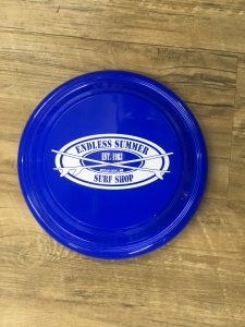 blue frisbee on table with surf shop decal