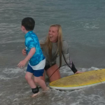 endless summer surf instructor giving young boy surf lesson