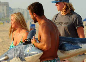Surf instructors holding an inflatable shark in Ocean City md